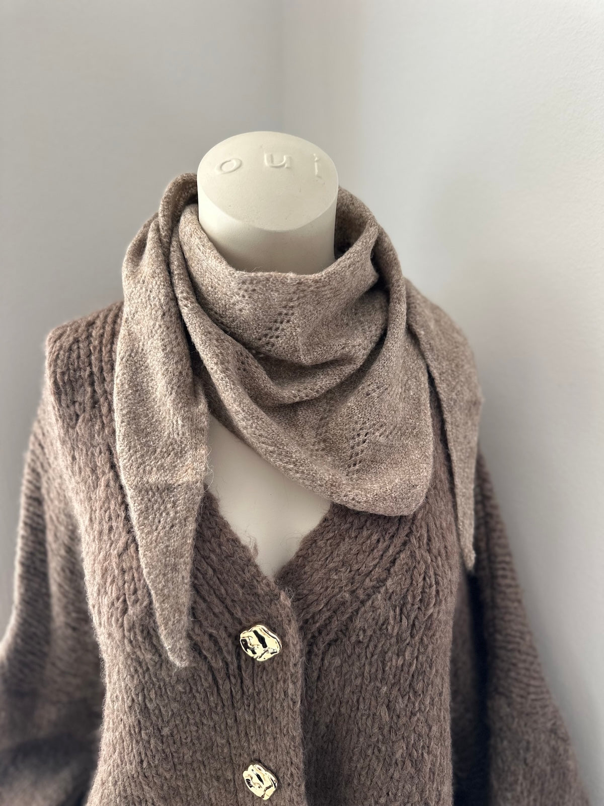 trukturiertes Dreiecks-Tuch Tessa in Taupe mit klarer Linienführung, elegant kombiniert mit einem grobgestrickten Cardigan.