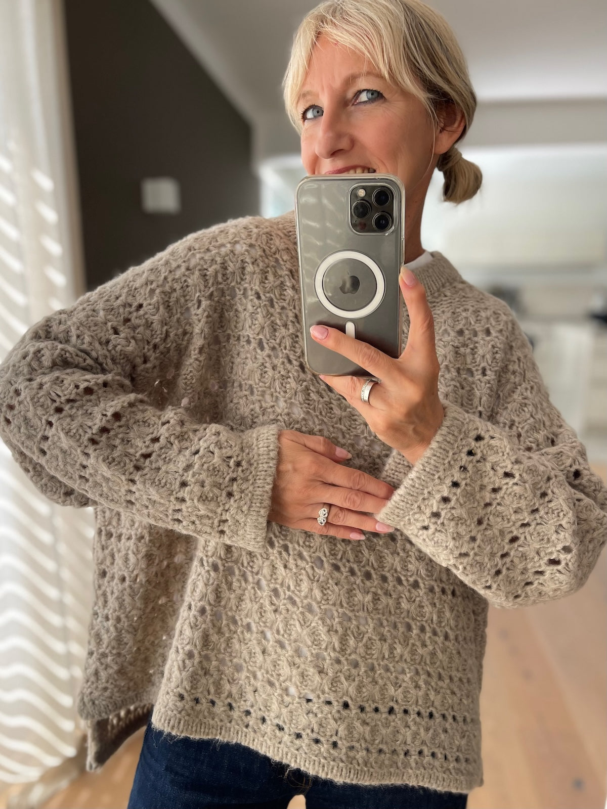 Sportlich eleganter Grobstrick Pullover Nomi in Taupe im modernen Boxy-Schnitt mit markanter Struktur, getragen zu einer dunklen Jeans.