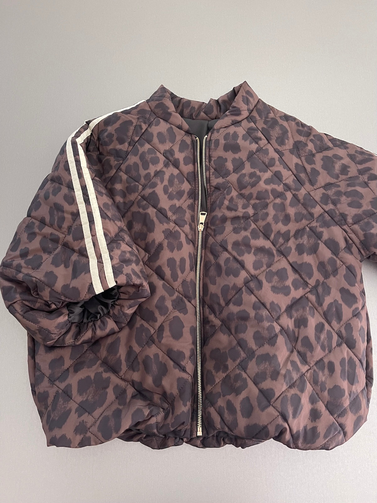 Frontansicht der kompakten Stepp-Jacke Hannah im Leo-Print, die durch den formstabilen Elastikbund am Saum eine klare Silhouette definiert.