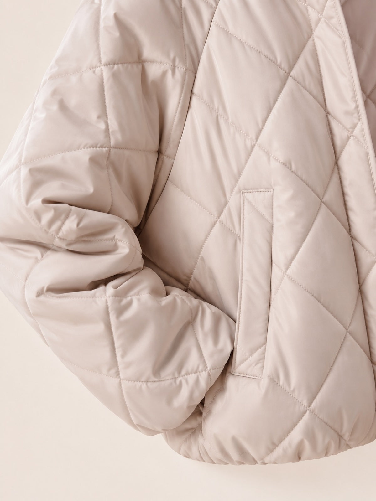 Detailansicht der beigen Stepp-Jacke Jany mit Fokus auf die seitliche Eingrifftasche und die hochwertige Materialstruktur.
