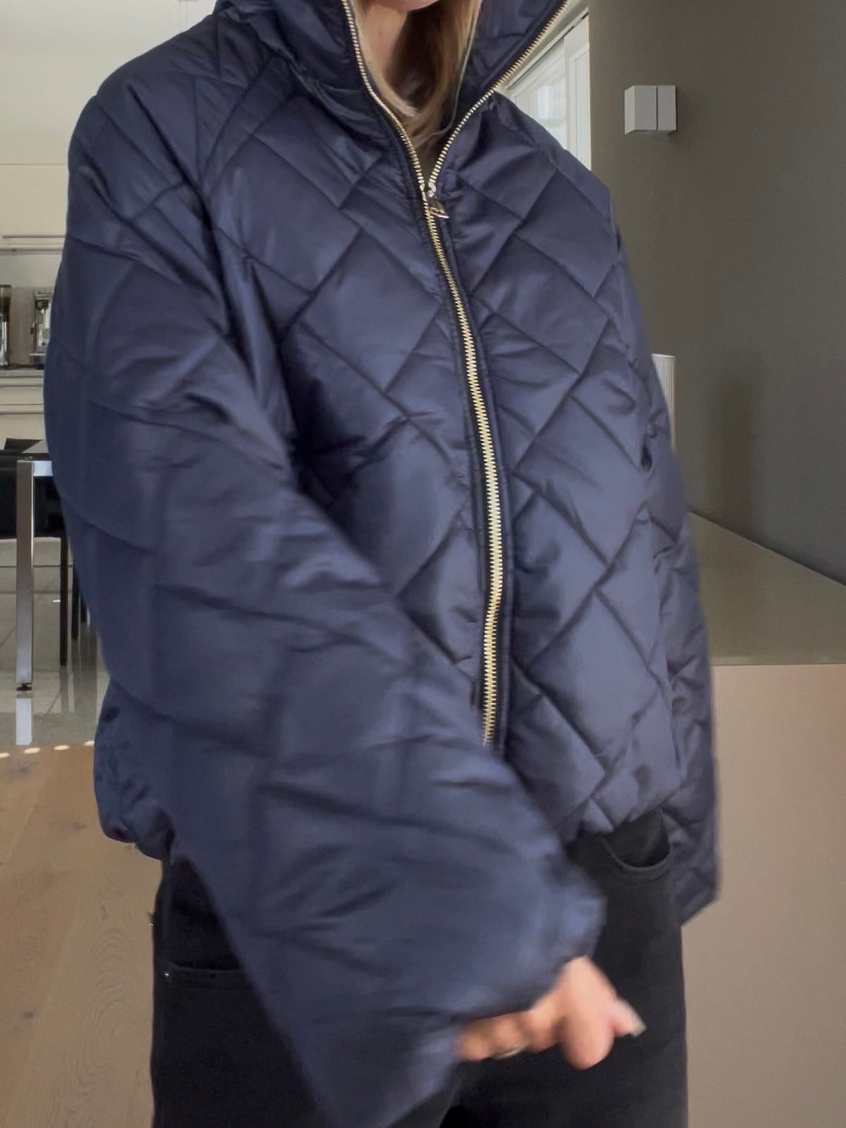 Nahaufnahme der Jacke Jany in Dunkelblau, welche den markanten Stehkragen, die prägnante Formsprache und den hochwertigen, goldfarbenen Reißverschluss im sportlich-eleganten Look zeigt.