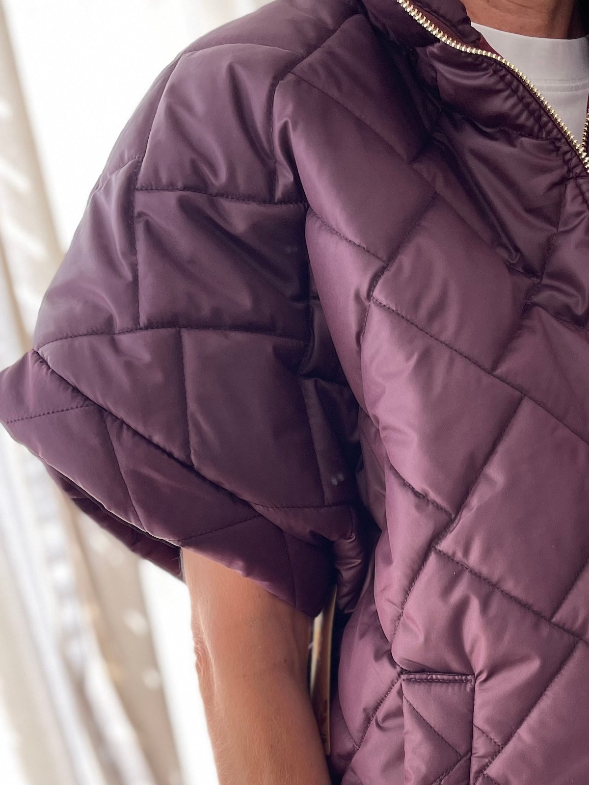 Detailansicht des Ärmelbereichs der Kurzarm-Steppjacke Ruby in Mulberry.