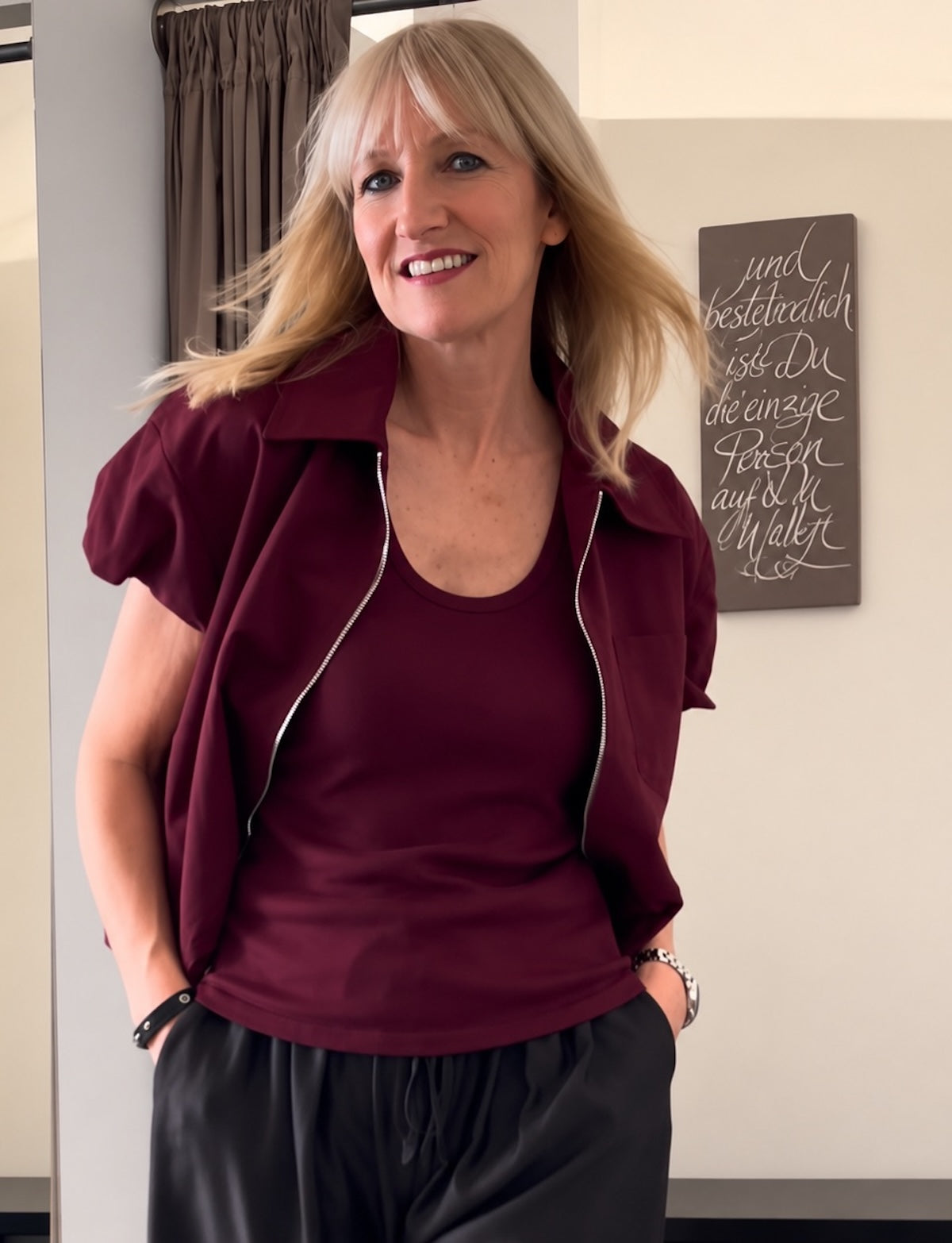 Damen Kurzarm Weste Ruth in Burgundi mit Metallic-Reißverschluss und Kragen, architektonische Silhouette, sportlich elegantes Layering-Outfit.