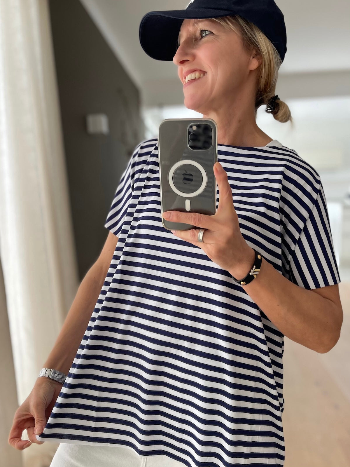 Lässiges Damen Oversize Shirt Elli in blau-weiß gestreift, sportlich kombiniert mit weißer Hose und dunkelblauer Cap, Seitenansicht