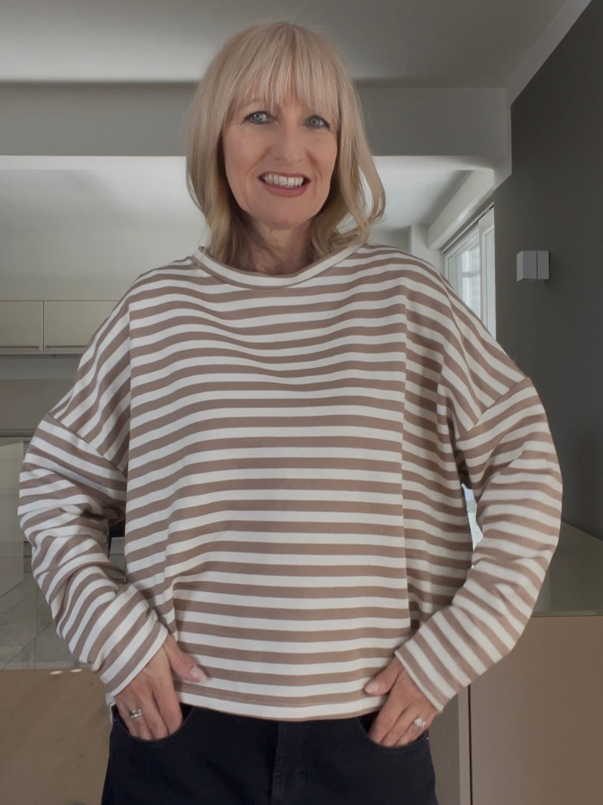 Nahaufnahme des gestreiften Shirts Velvet in Beige-Zimt, welche die prägnante Formsprache und den cleanen, paspelierten Rundhalsausschnitt sportlich-elegant demonstriert.
