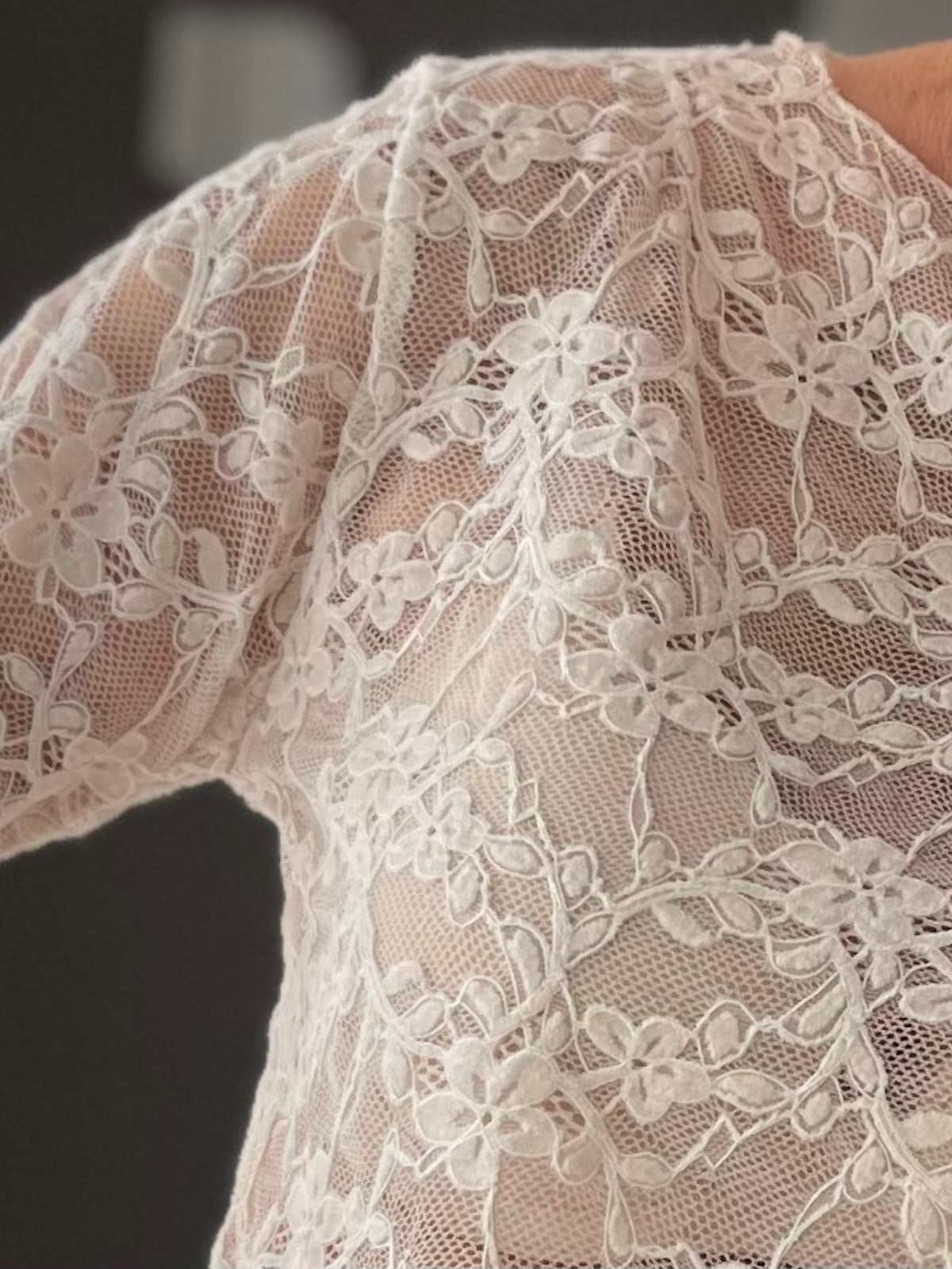 Detailansicht der floralen Spitzenoptik des formstabilen Langarm-Shirts Mary in Creme-Beige.