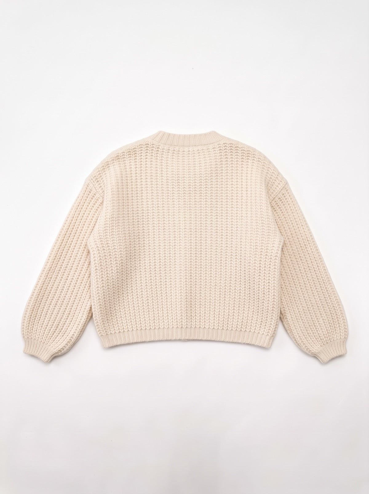 Rückansicht des weiten creme-naturfarbenen Grobstrick Cardigans Greta von SILKE MODEN mit strukturiertem Volumen und schmalen Ärmelbündchen.