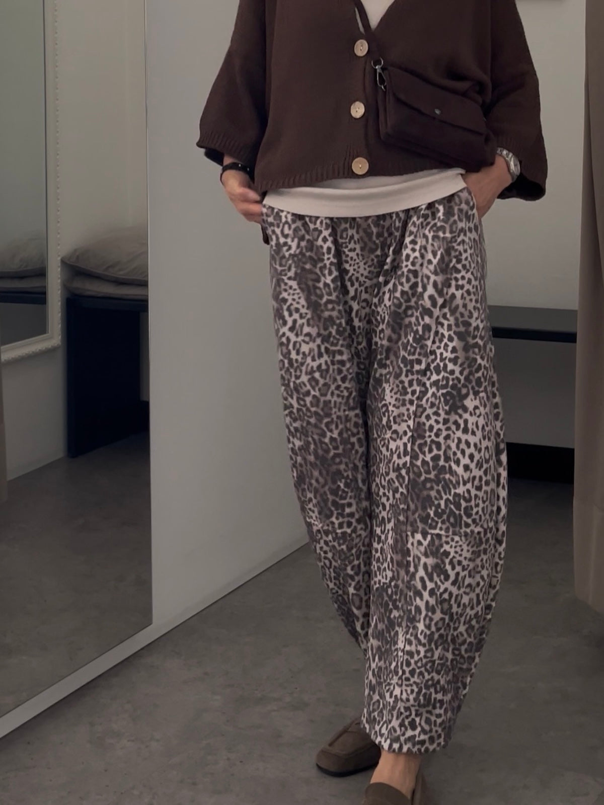 Eine modische Dame trägt die fließende Hose Brooke in Leo-Optik, kombiniert mit einem braunen Cardigan und eleganten Loafern. SILKE MODEN Kitzingen.