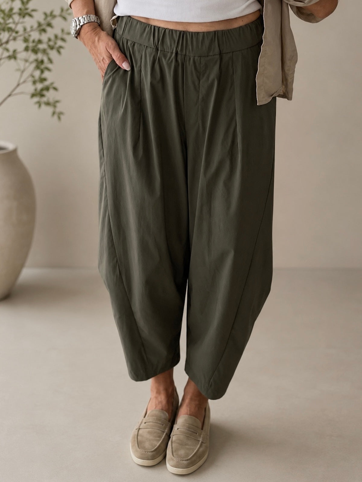Nahaufnahme der khakigrünen Hose Elisa von vorne zur detaillierten Darstellung der modern definierten Beinsilhouette, der feinen Bundfalten und des flexiblen Raffbunds.