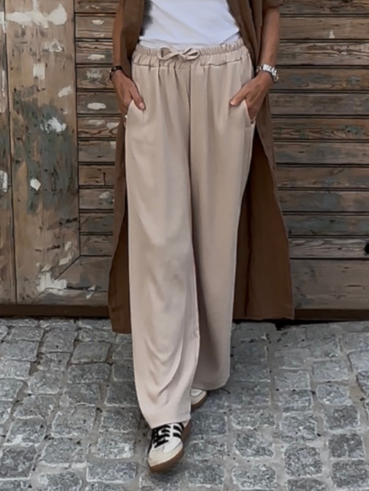 Frontalansicht der fließenden Damen-Stoffhose Tracy in Stone mit elastischem Gummibund und seitlichen Eingrifftaschen, ideal für einen lässigen Alltags-Look.