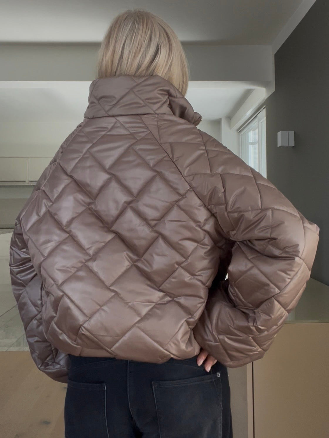 Jacke Jany von hinten in der Trendfarbe Taupe mit edlem Rauten-Steppmuster, gestylt im strukturierten Cropped-Schnitt mit weiten Ärmeln und goldfarbenem Reißverschluss.