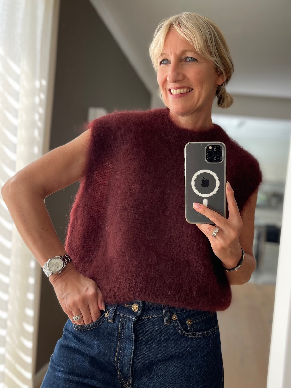 Dame trägt den eleganten Mohair Pullunder Hazel in sattem Mulberry im sportlich-eleganten Layering-Look.
