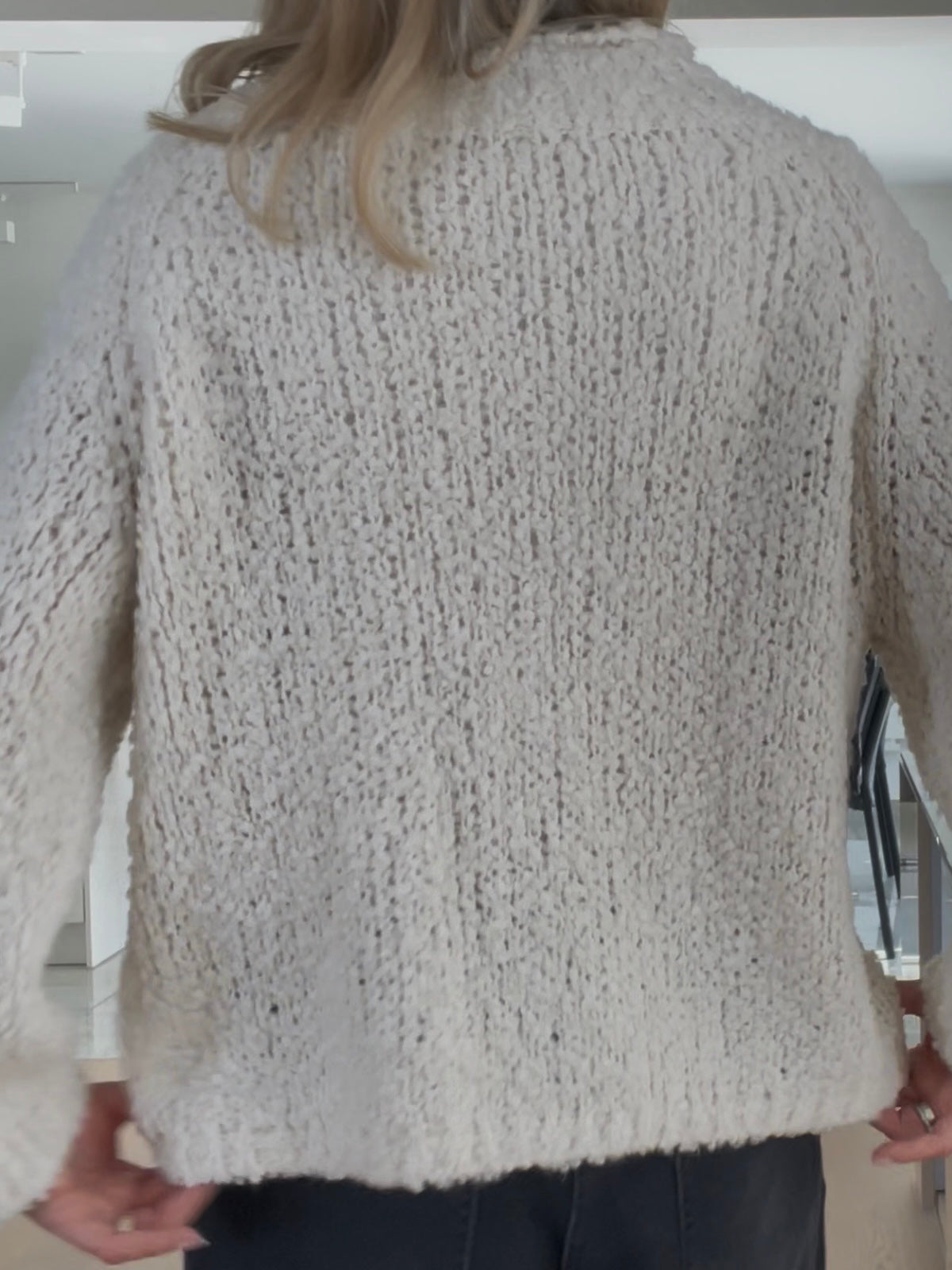 Nahaufnahme der Rückseite des Pullovers Jola in Creme, welche die griffige, feste Haptik und die hochwertige Struktur des groben Maschenbilds hervorhebt.