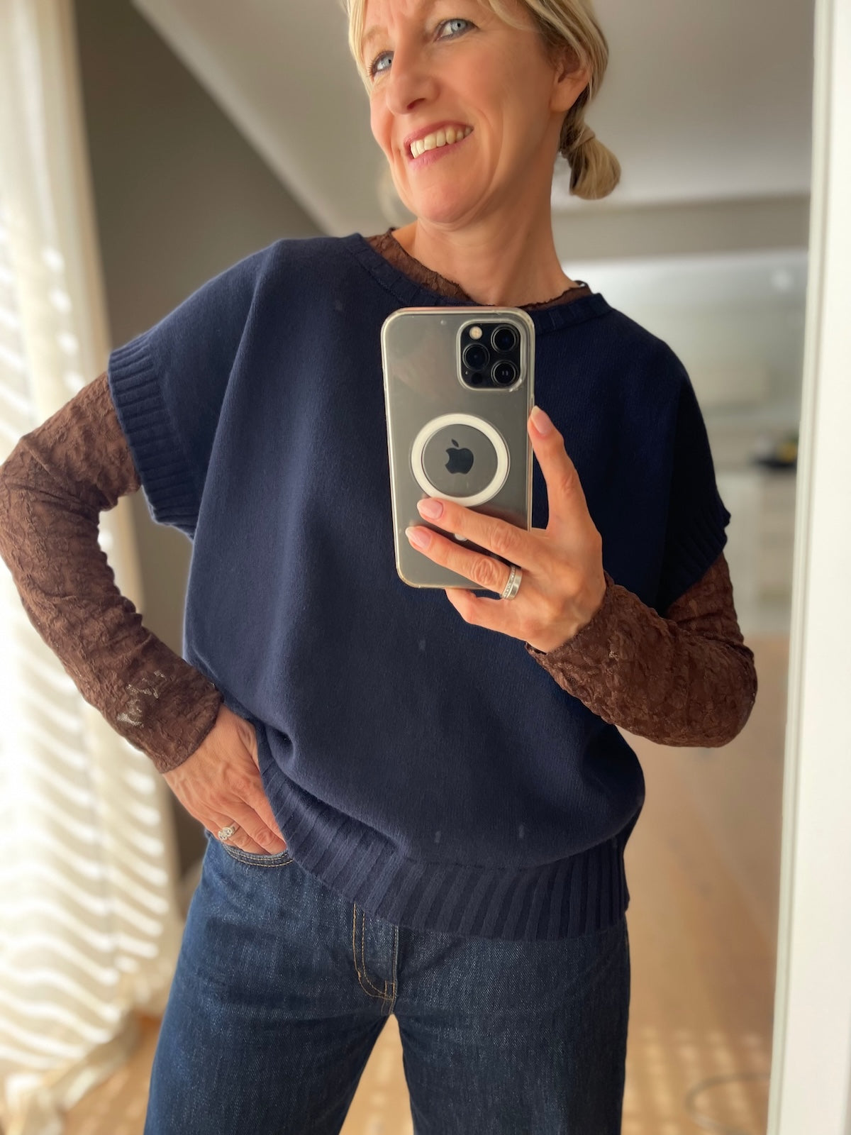 Dame präsentiert den edlen Feinstrick Pullunder Bianca in tiefem Blau mit überschnittenen Schultern im Layering-Look.