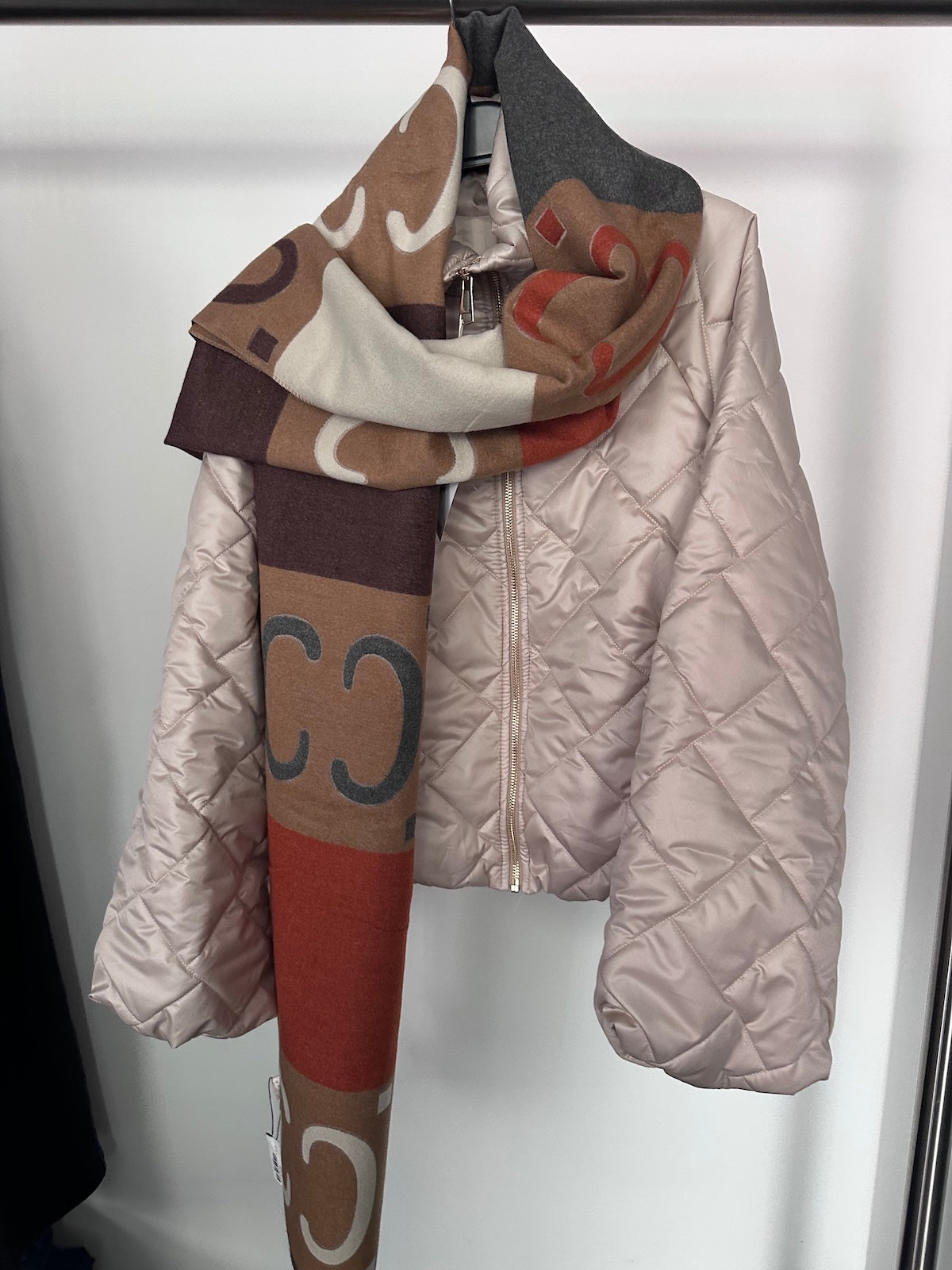 Exklusiver Schal Guccini in warmen Herbstfarben mit klar definierter Linienführung, formstabil und strukturiert drapiert über einer hellen Steppjacke.