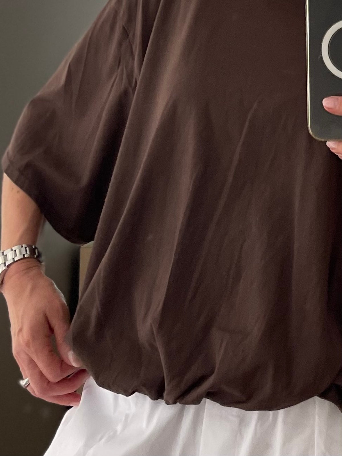 Exklusives Damen T-Shirt Emily in tiefem Braun im edlen Boxy-Style, Fokus auf den formstabilen Elastikbund am Saum, den lockeren Fledermaus-Ärmelansatz und den kurzen Sitz auf der Hüfte