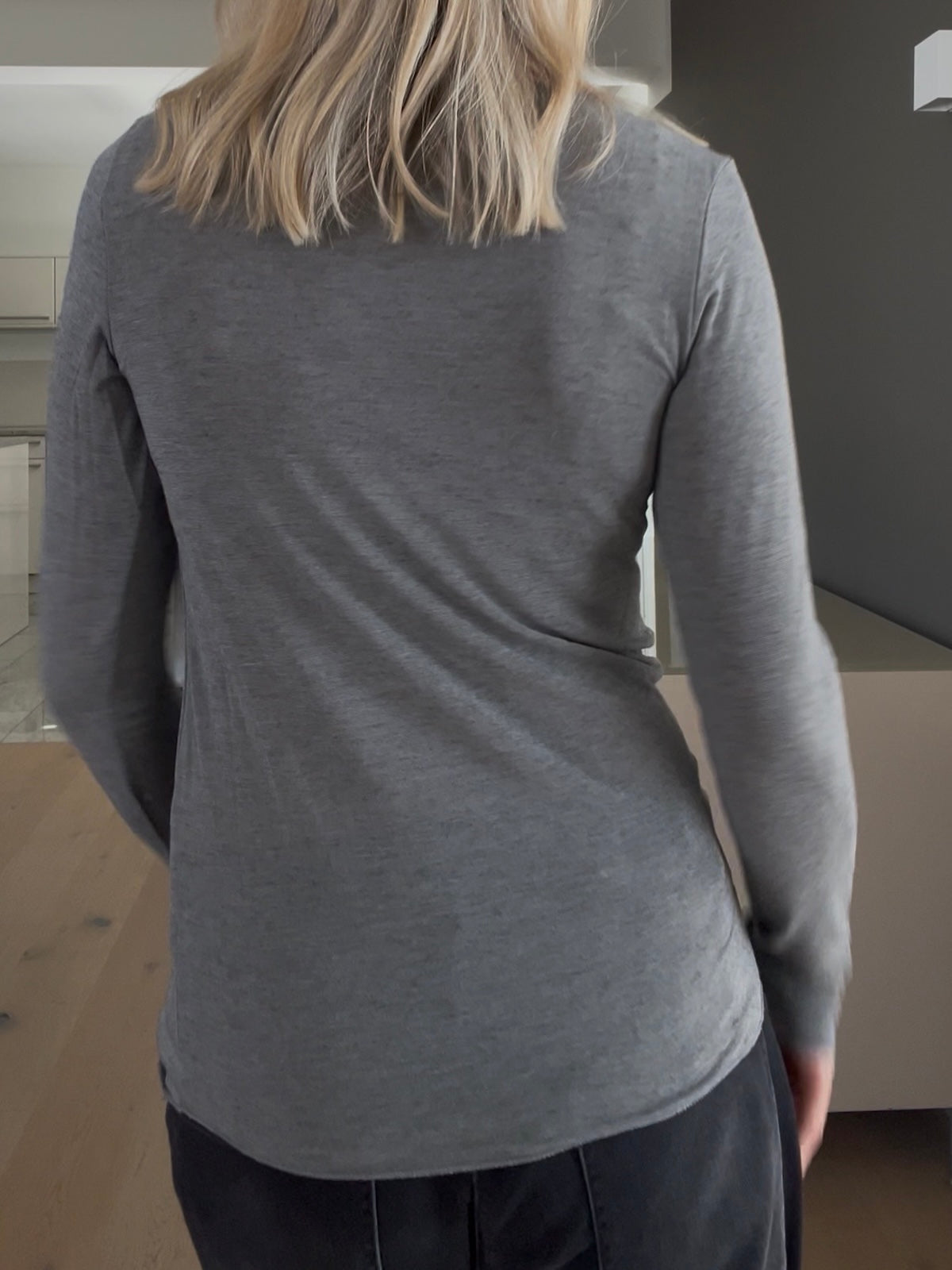 Rückansicht des feinen Shirts Luna in Grau, die den körpernahen Sitz und die cleane Silhouette des Cashmere-Mix-Materials zeigt.