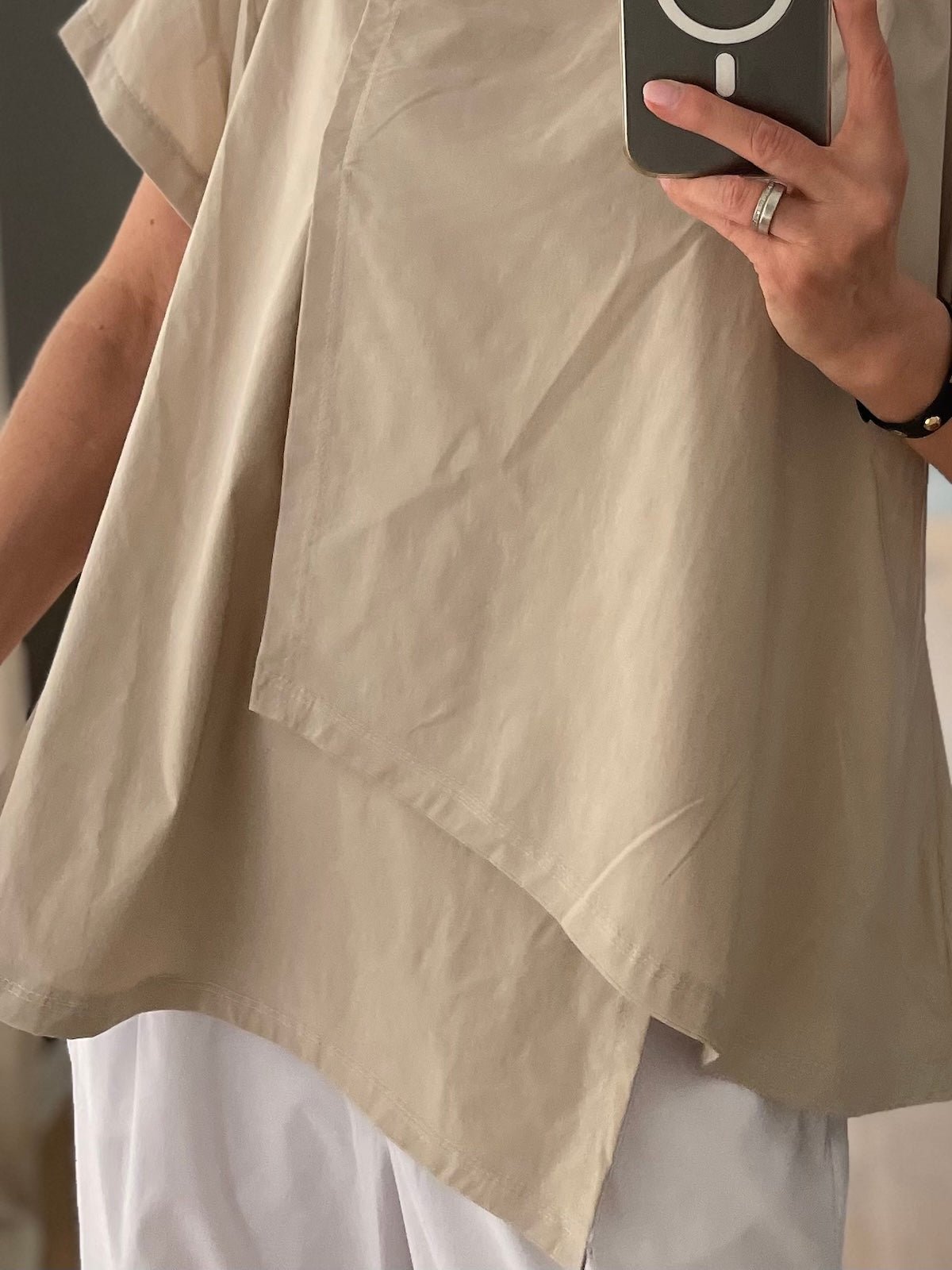 Detailaufnahme des Damen Shirts Marta in Stone, Fokus auf die asymmetrische Schnittführung der Vorderseite und das hochwertige, leicht fallende Material –