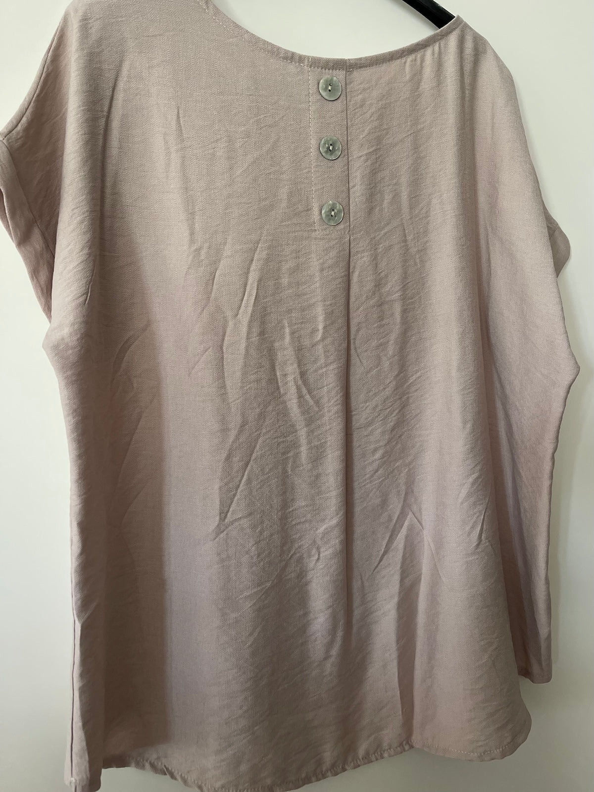 Detailansicht der Rückseite des Shirts Diana in Taupe. Der Stoff aus Viskose-Mix fällt fließend, verziert mit einer eleganten Knopfleiste mit drei hellen Knöpfen am oberen Rücken.