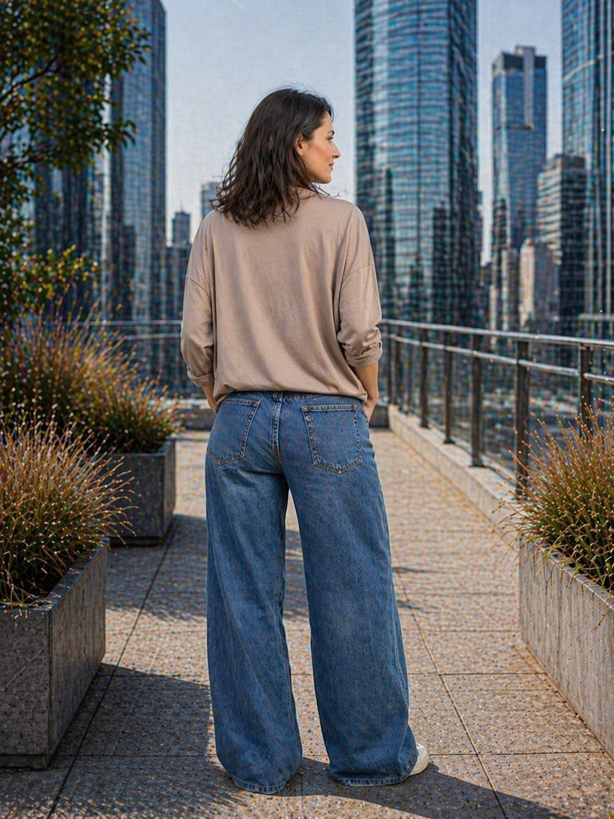 Lässiges Damen Oversize Sweatshirt Kate in der Farbe Taupe, sportlich kombiniert mit einer weiten blauen Jeans und weißen Sneakern, Back Ansicht.