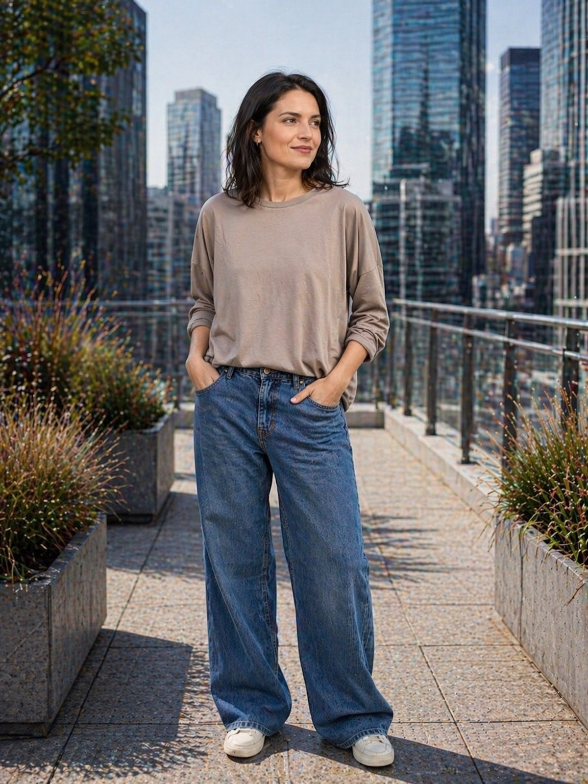 Lässiges Damen Oversize Sweatshirt Kate in der Farbe Taupe, sportlich kombiniert mit einer weiten blauen Jeans und weißen Sneakern, Frontanssicht