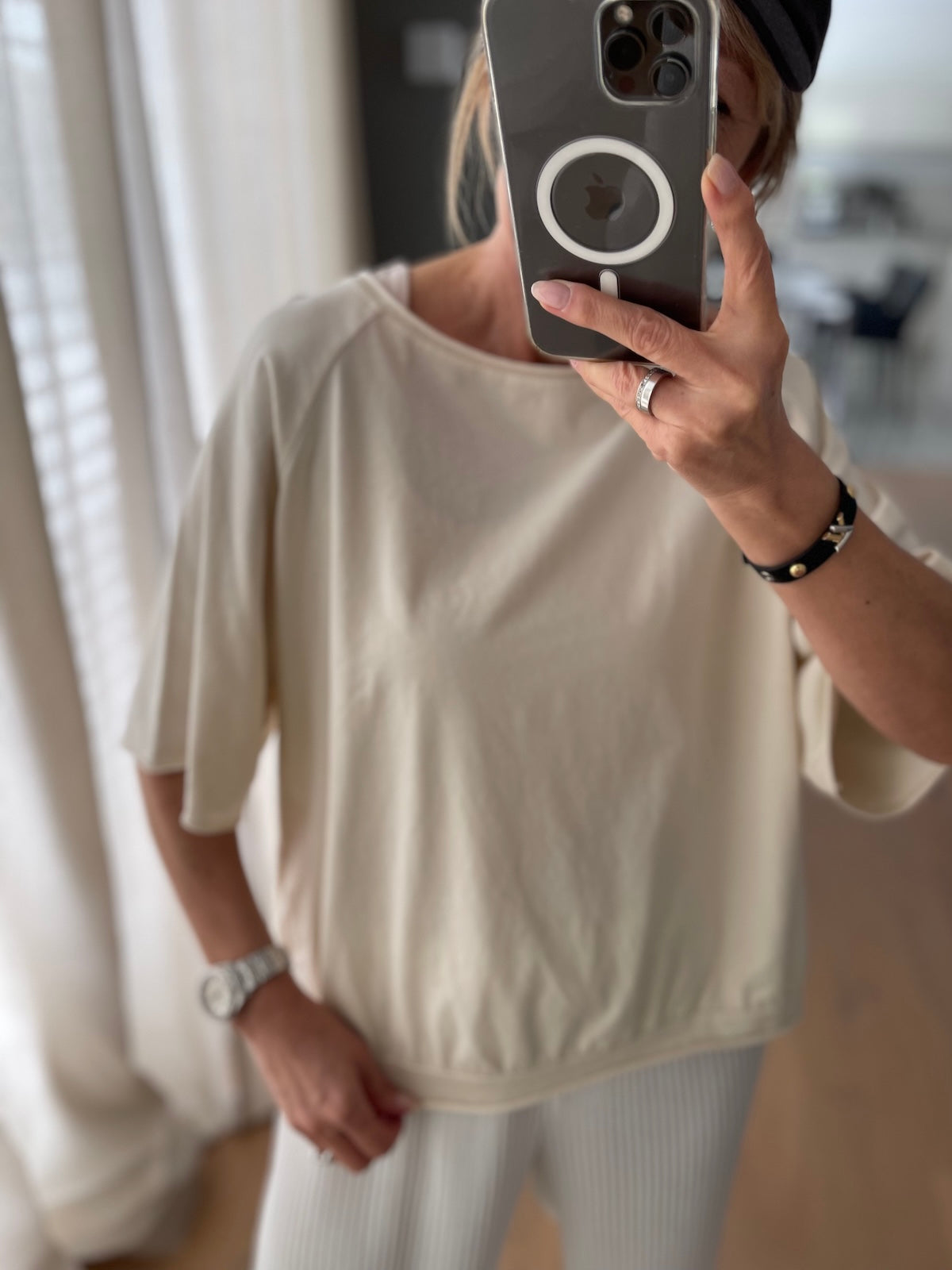 Spiegel-Selfie eines Modells im cremefarbenen T-Shirt Mary. Der lockere Fall der Baumwolle und der weite Halsausschnitt werden hier besonders schön präsentiert.